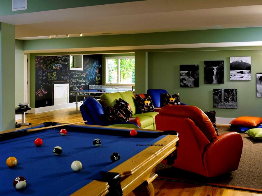 اتاق بازی خانگی که درون آن میز بیلیارد، میز پینگ پنگ و مبل های قرمز و سبز چیده شده است